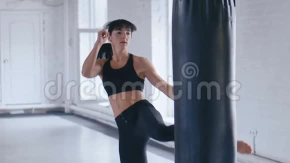 跆拳道职业运动员女子在健身房踢拳袋体育跆拳道女子在健身房训练视频的预览图