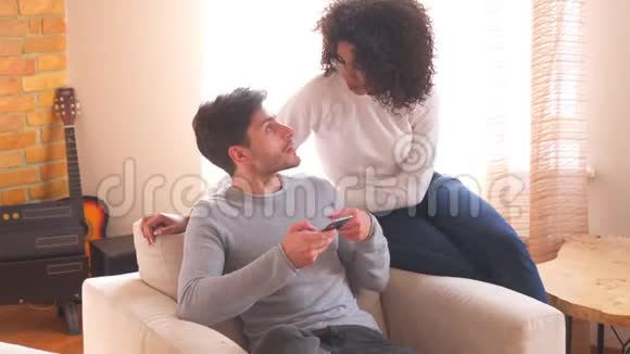 一对夫妇用手机聊天在扶手椅上放松视频的预览图