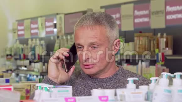 在药店购物的时候老人在打电话视频的预览图