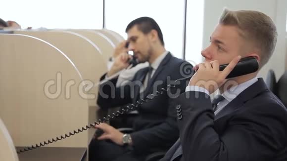 呼叫中心的接线员正在电话中交谈而坐在领导公司视频的预览图