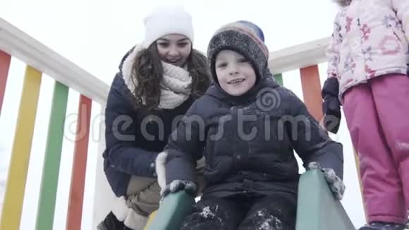 滑动冬天的公园孩子们操场在冬季公园散步的孩子视频的预览图