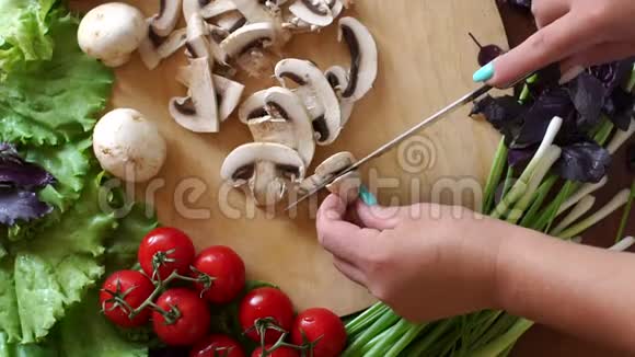 一个女人在木制砧板上切蘑菇的特写视频的预览图