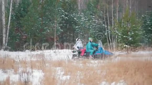 冬季森林高速驾驶雪地摩托的年轻人视频的预览图