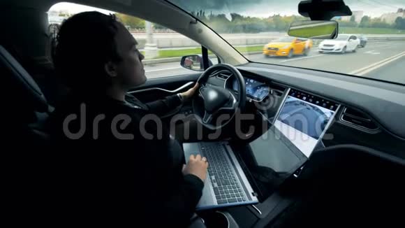 一个人在操作笔记本电脑的时候慢慢地开着车视频的预览图