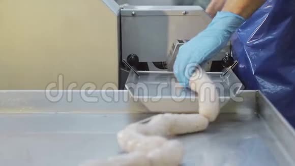 生产工人戴蓝色橡胶手套做香肠香肠的特写是由一个雇员创作的视频的预览图