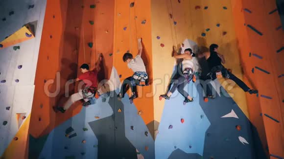 体育运动员在现代攀岩墙上近距离视频的预览图