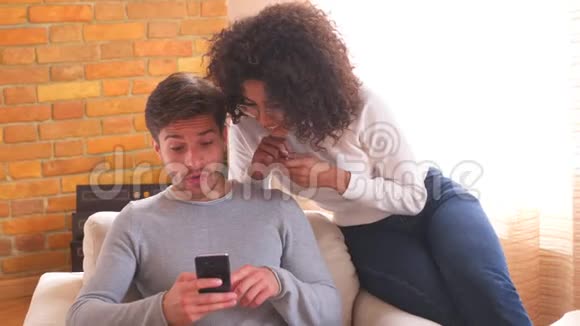 一对夫妇用手机在家里不和视频的预览图