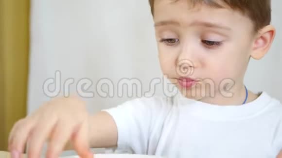 一个孩子正在吃一个白色盘子里的薯片特写相机的移动视频的预览图