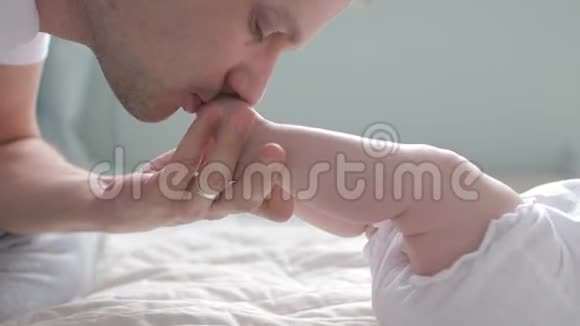 近距离拍摄父亲亲吻婴儿的脚视频的预览图