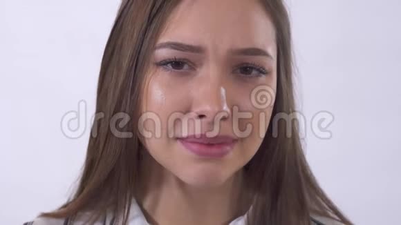 合上年轻哭泣的女人的肖像在摄影棚拍摄白色背景视频的预览图