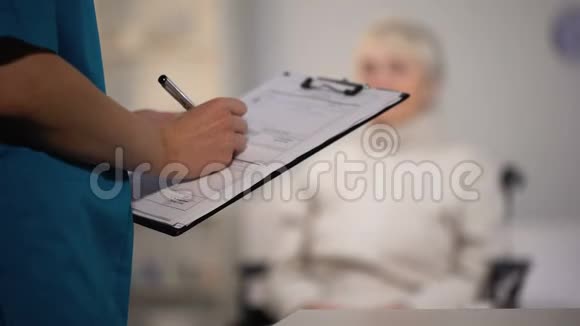 治疗师在病历中做笔记检查老太太医院视频的预览图