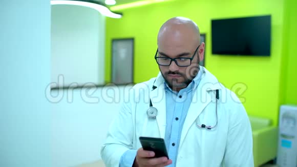 医生用手机发短信使用手机的男医生医生用智能手机视频的预览图