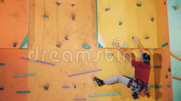 年轻人移动手臂爬在墙上靠近视频的预览图
