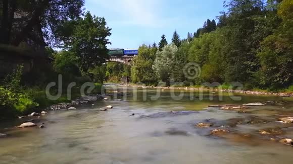 火车穿过高山上的一块石头一条浅河喀尔巴阡山上有一股湍急的水流视频的预览图