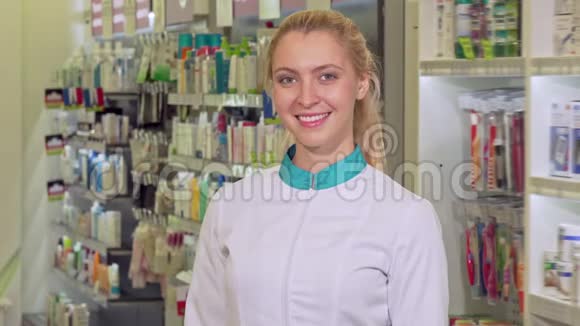 快乐的女药剂师交叉双臂骄傲地在她的药店摆姿势视频的预览图