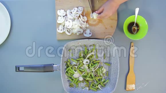 女性手在盘子里切香姜菇视频的预览图