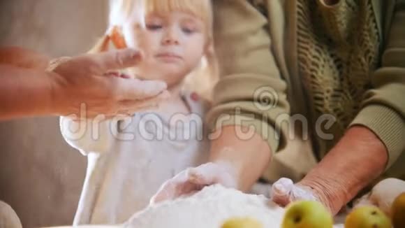 一个金发小女孩摸着面团从手中抖掉面粉视频的预览图