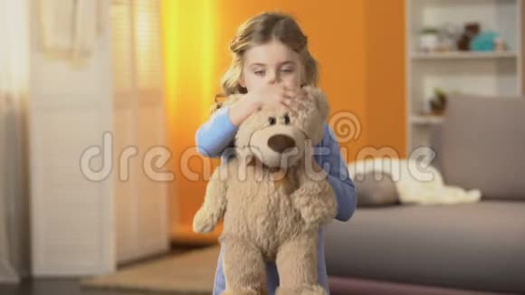 可爱害羞的卷发女孩躲在最喜欢的泰迪熊后面童年心理视频的预览图