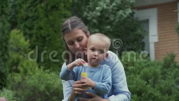 妈妈和小男孩正在后院开始肥皂泡视频的预览图
