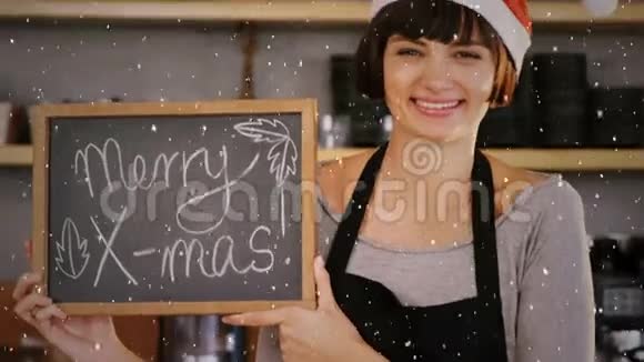 带着问候的圣诞帽举牌咖啡店老板身上下着雪的视频组合视频的预览图