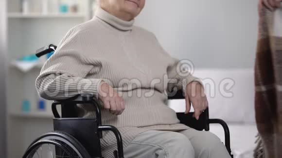护士用轮椅上的毯子轻轻覆盖关心老人视频的预览图