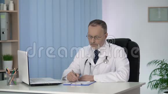 医生在病人病历中书写查看照相机诊所服务视频的预览图