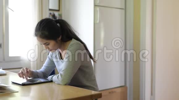 年轻美丽的亚洲女性用数字平板电脑靠窗视频的预览图