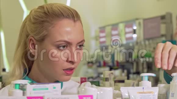 女药剂师在货架上组织产品在药店工作视频的预览图