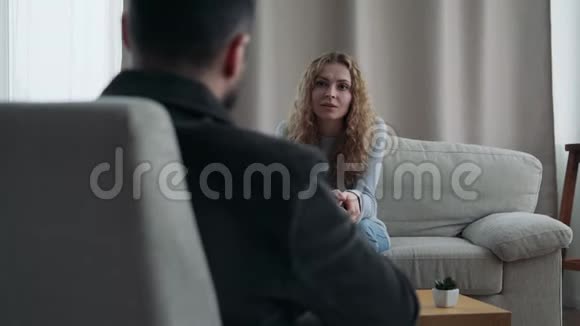坐在沙发上跟他的治疗师说话的女人视频的预览图