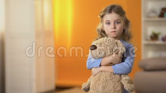被遗弃的心烦意乱的卷发女孩抱着最喜欢的泰迪熊在孤儿院感到悲伤视频的预览图