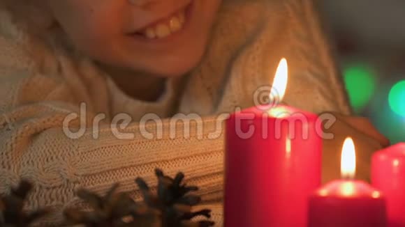 快乐的孩子看着燃烧的蜡烛等待圣诞特写的奇迹视频的预览图
