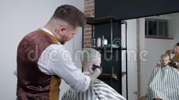 理发师在理发店为顾客理发用理发器人理发在理发店刮胡子视频的预览图