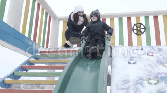 滑动冬天的公园孩子们操场男孩滑了下来视频的预览图