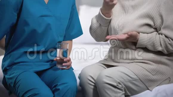 护士给老妇人吃药和棒棒糖照顾病人视频的预览图