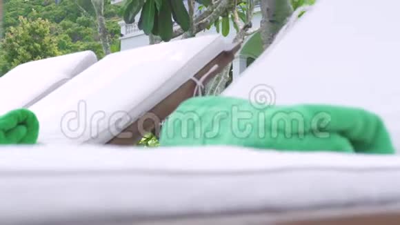 背景豪华别墅和绿色草坪上的躺椅和雨伞绿色草坪和白色小屋上的躺椅视频的预览图