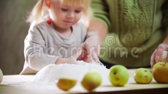 一个小女孩摸着面粉里的面团做小馅饼视频的预览图
