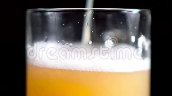 极致的特写镜头将工艺金啤倒入透明玻璃慢杯中视频的预览图