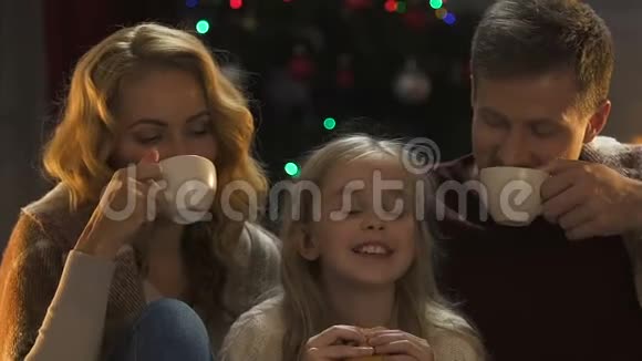 美丽的家庭享受圣诞前夜喝热巧克力和饼干视频的预览图
