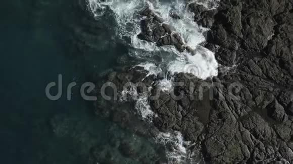 鸟的视野拉回海浪撞击岩石海岸线视频的预览图