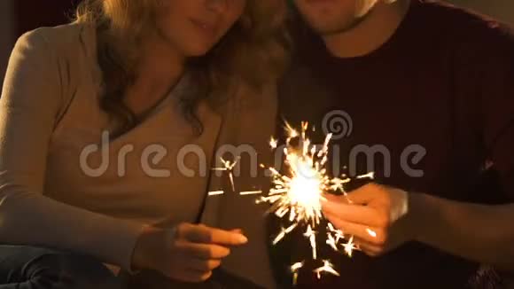 情侣们手持孟加拉灯亲吻庆祝除夕视频的预览图
