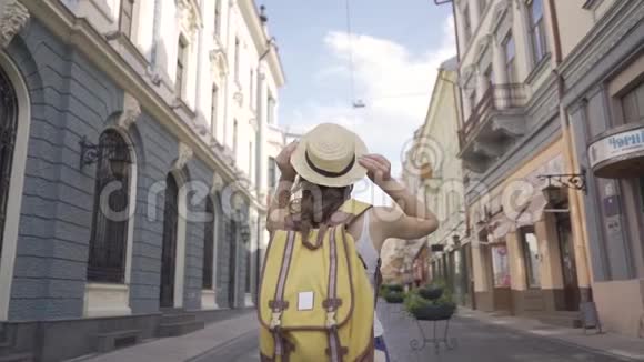 镜头跟随年轻女子背着背包走在拥挤的小街道上有着令人惊叹的建筑拥有伟大的视频的预览图