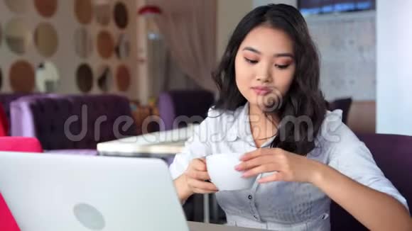 亚洲女商人用笔记本电脑思考和看屏幕和打字视频的预览图