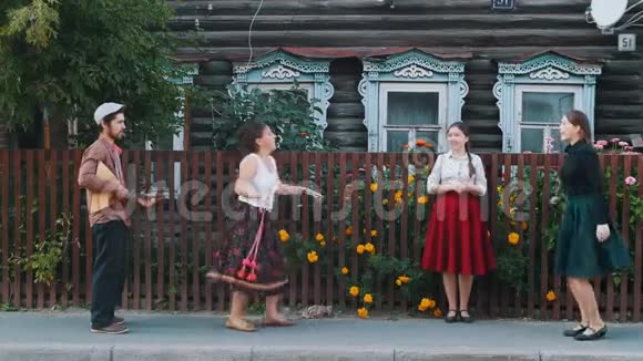 在村里的街道上年轻的妇女随着音乐跳舞视频的预览图
