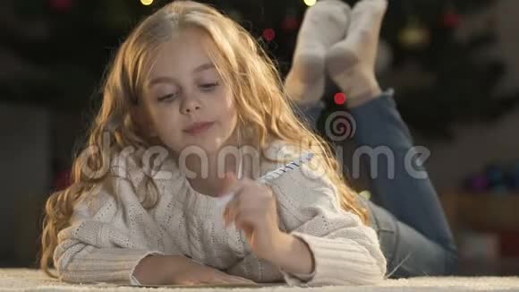 兴奋的女孩写信给圣诞老人梦见礼物堆童年视频的预览图