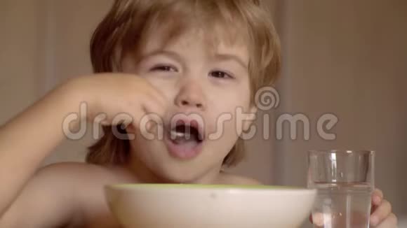 小男孩在厨房吃早餐小宝宝在吃东西饥饿的小男孩在吃东西坐在上面的小孩视频的预览图