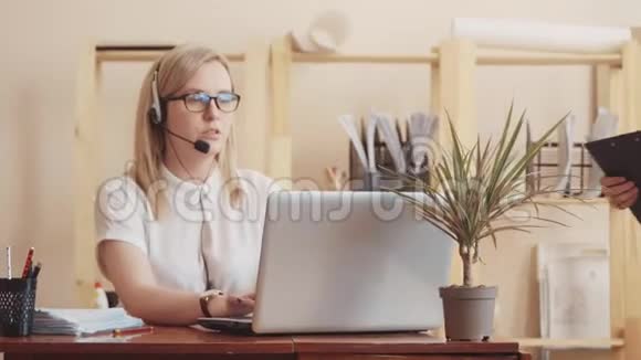 白人女性呼叫中心接线员在电脑上工作走到她的经理面前交流视频的预览图