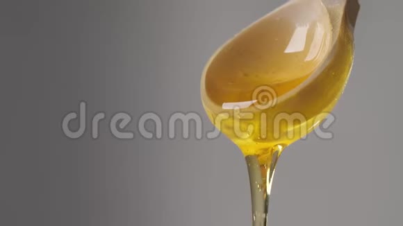 从木制蜂蜜勺子里滴出的蜂蜜视频的预览图