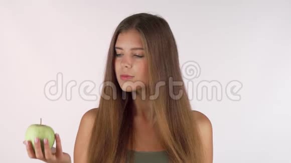 长头发的年轻女子在苹果和甜甜圈之间选择视频的预览图
