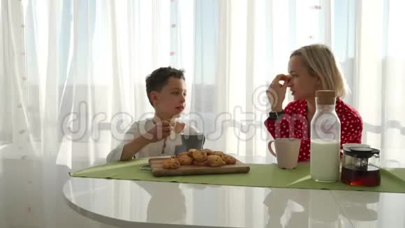 一个可爱可爱的白种人男孩正在他金发的年轻母亲旁边吃饼干弟弟在偷东西视频的预览图