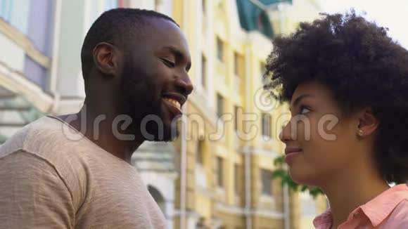 微笑的非洲男人拥抱女朋友相爱的情侣户外约会视频的预览图